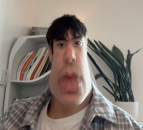 Deven Ballback, photographed from below mid-sentence, face noticeably distorted